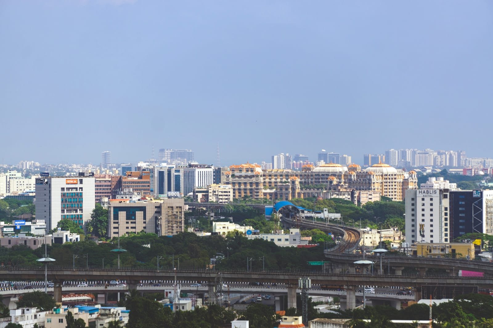 Illustrative image: Chennai skyline with office towers, an elevated metro line and flyovers.
